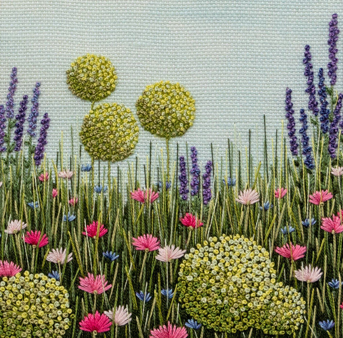 Close up of the finished Allium Meadow kit.  The stitching detail of the allium heads, salvias, and other pink and blue flowers are clearly seen.