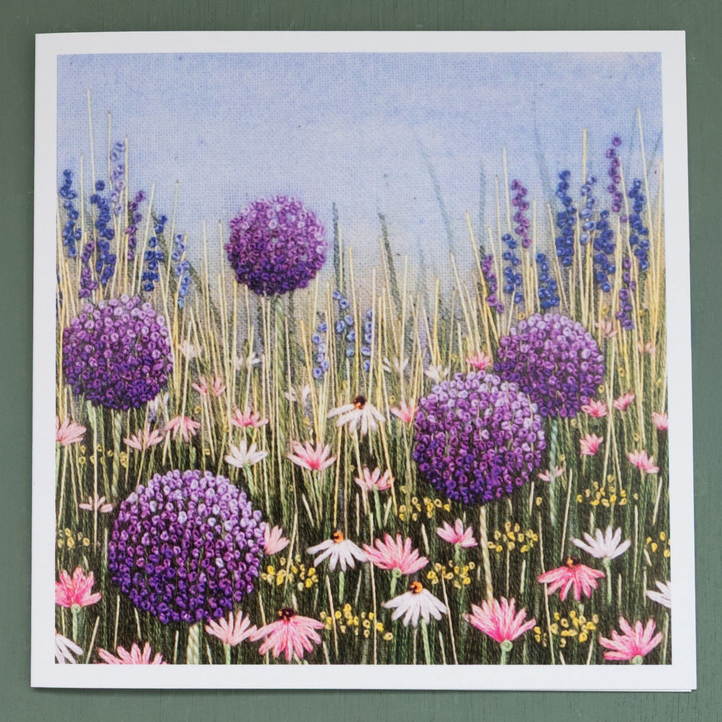 Square greeting card  with purple alliums, blue salvias and pink daisies.