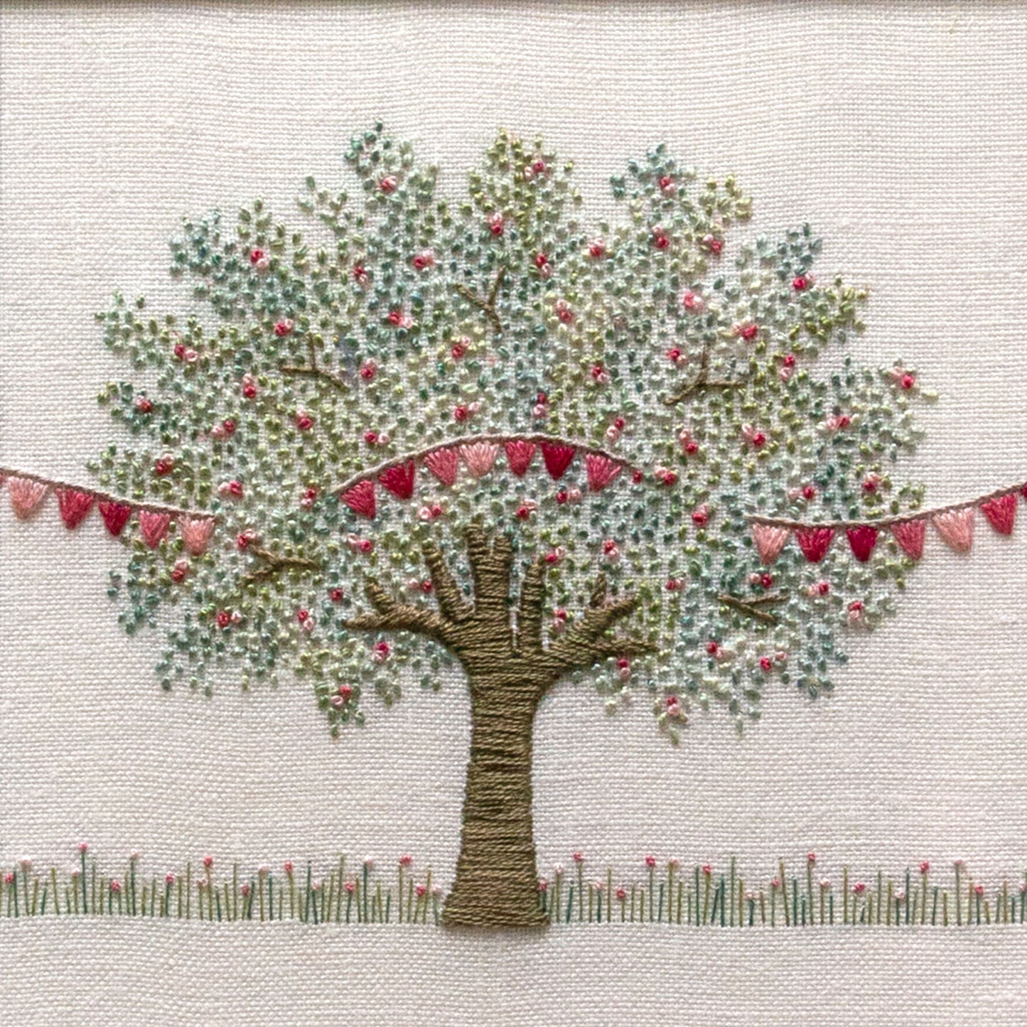 A pretty apple tree with a string of pink bunting running through from left to right