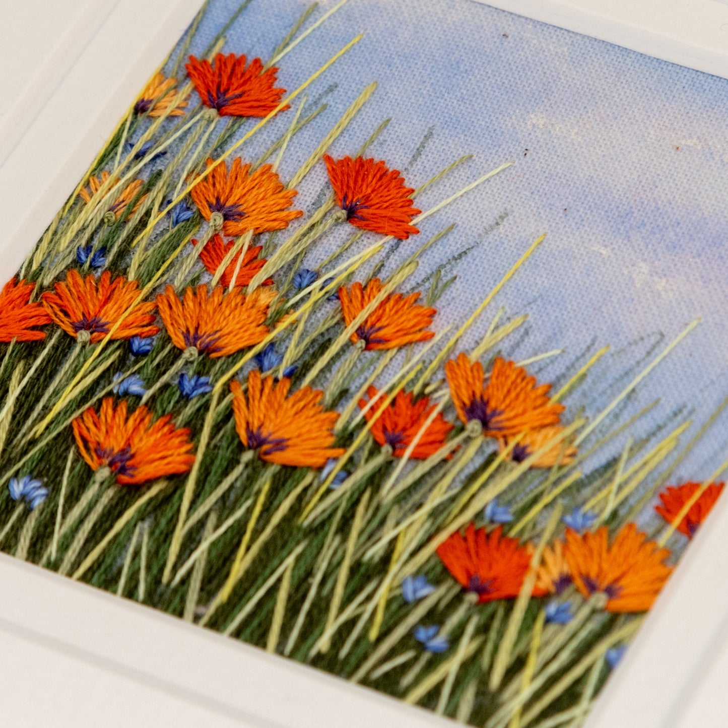 bright orange Californian poppies amongst the grasses in this embroidered artwork