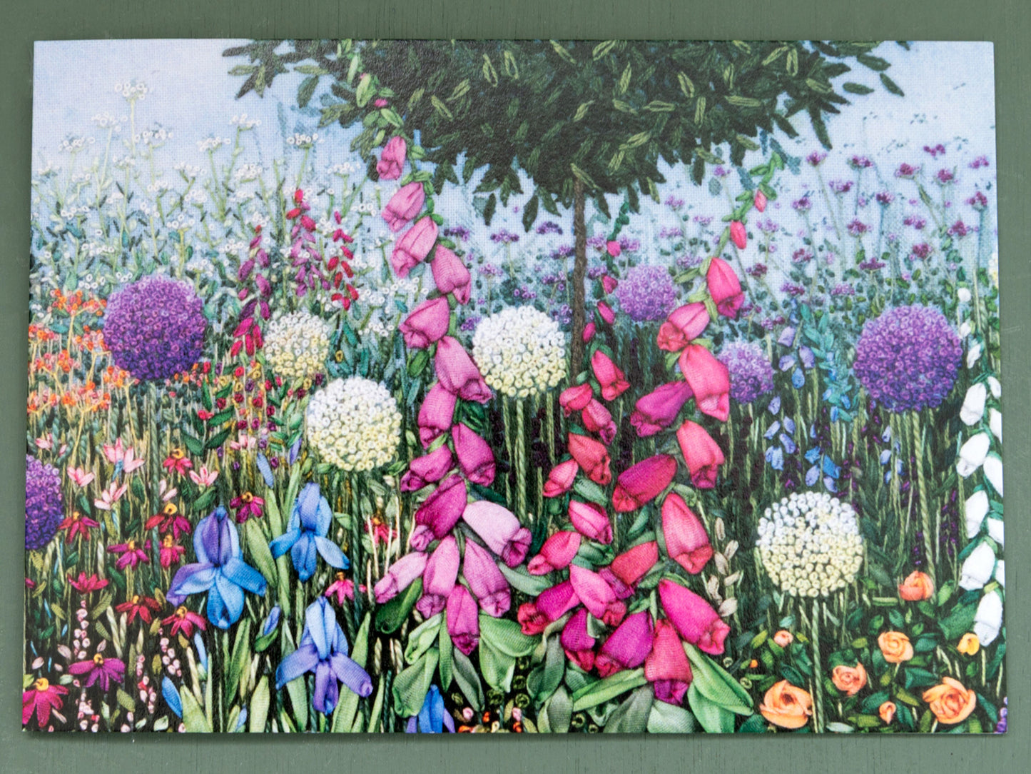 Colorful garden scene with various flowers on a card