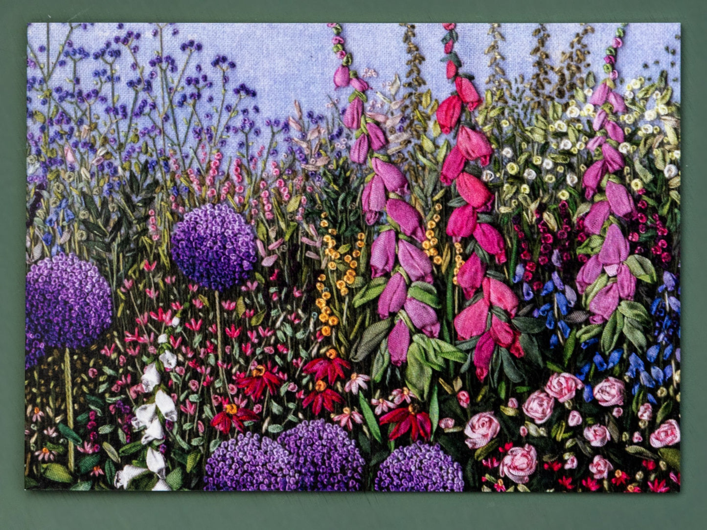 The front of a printed greeting card of a full colourful flower border.