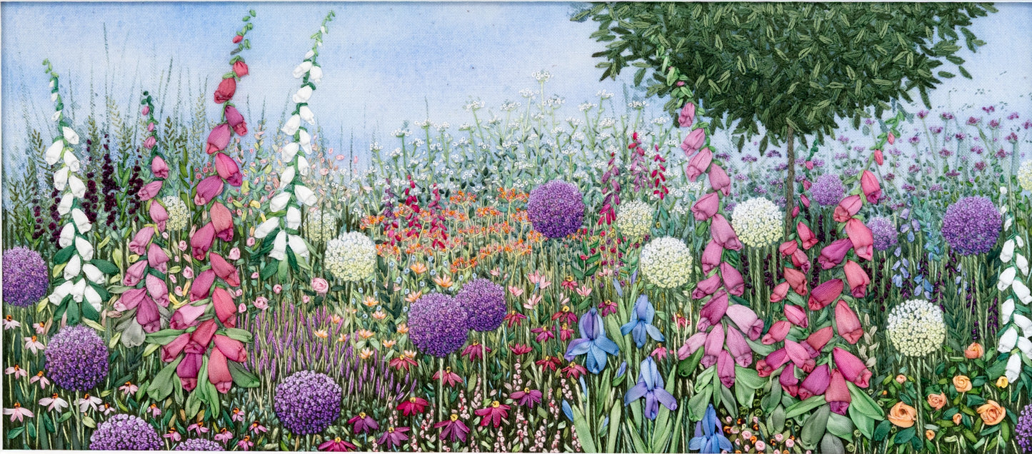 A colourful flower border of foxgloves and irises stitched using hand dyed silk ribbons. white and purple alliums,  mixed in with other colourful flowers and a bay tree rising above.
