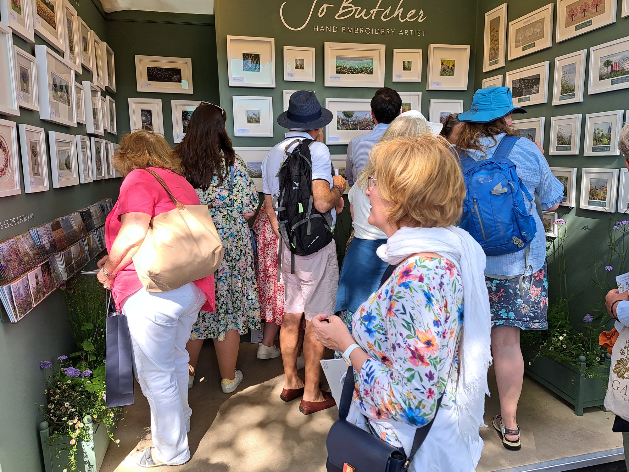 people looking at Jo butcher's embroideries on her stand at RHS Flower Show.