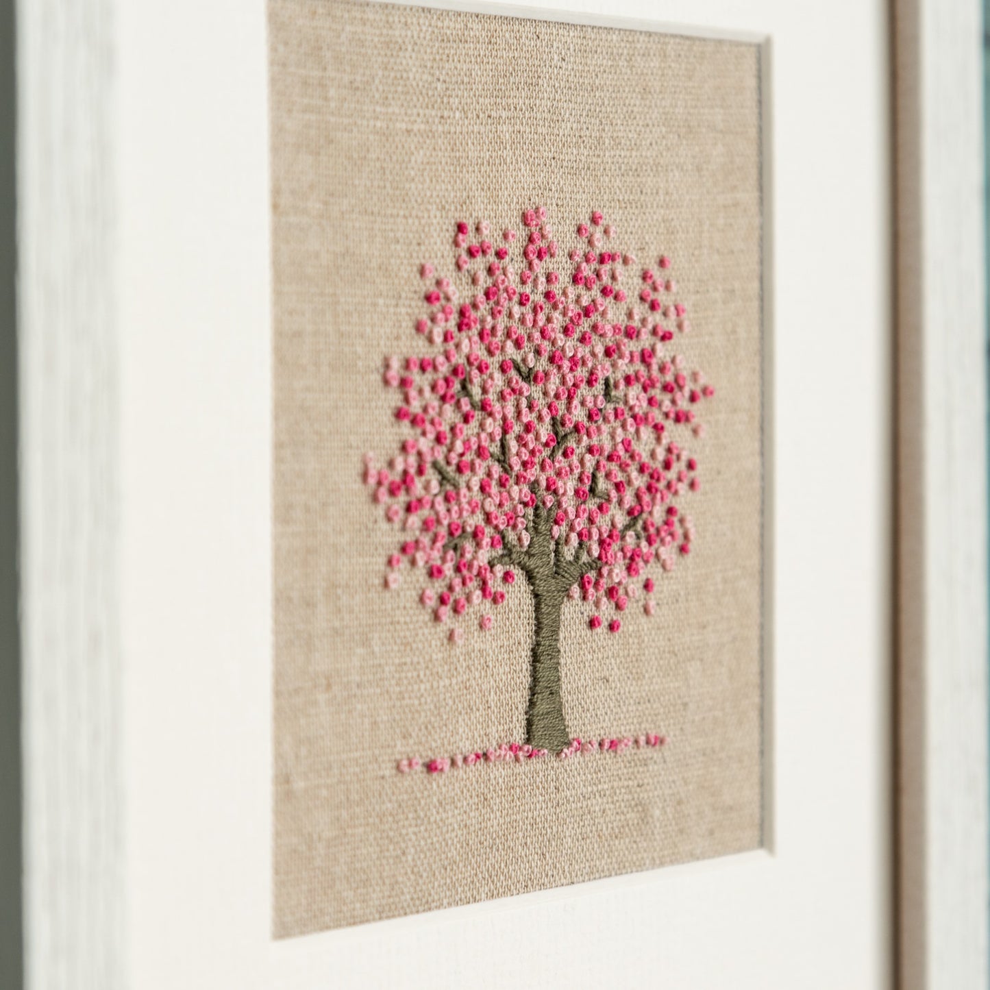 Framed cheery tree kit close up from the left to show stitching details.