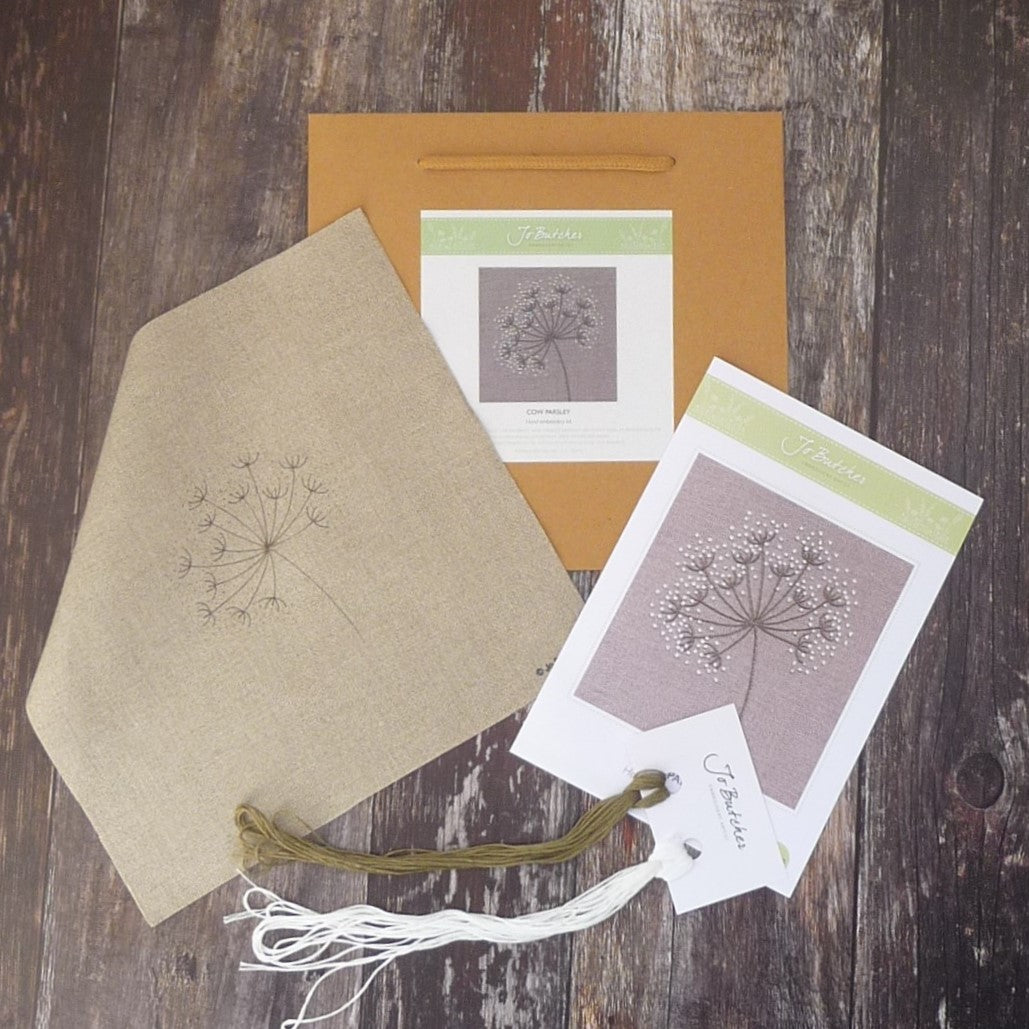 kit contents for cow parsley on beige displayed with printed background, cottons, instruction sheet with image and brown paper bag
