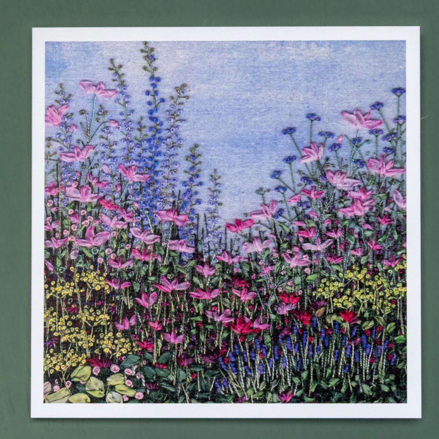 A card of a densely populated flower border with tall delphiniums and Japanese anemones standing proud above.
