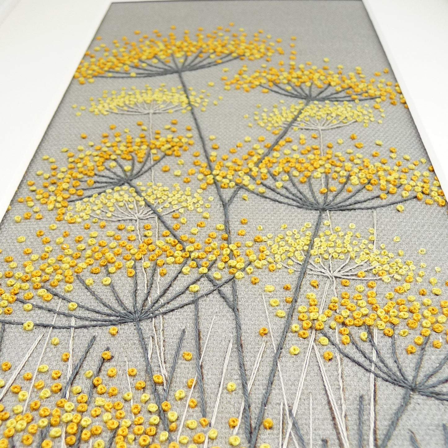 close up of the various shades of yellow French knot that make up this contemporary embroidery kit.