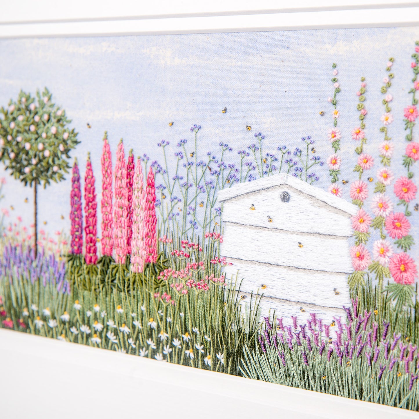 detail of the stitched hollyhocks, hive, daisies and lavender are clearly seen.