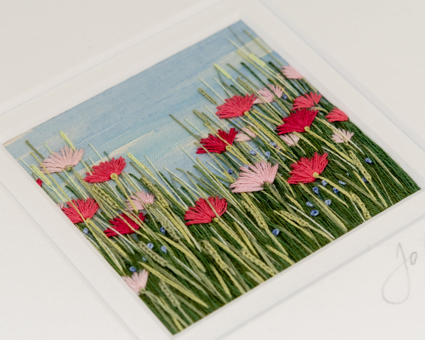 close up view of different shades of pink flowers nestled amongst the grasses
