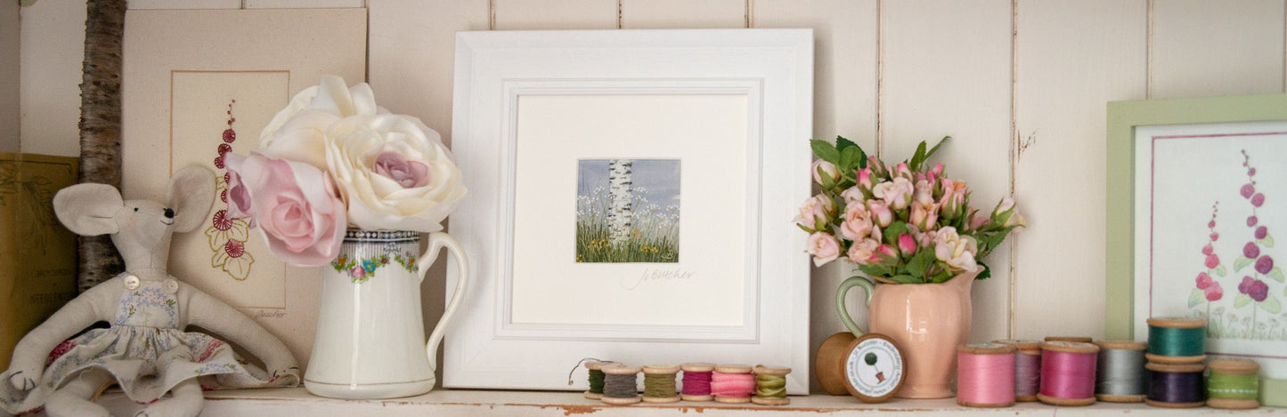 shelf with one of Jo's original artworks staged with cotton reels and flowers