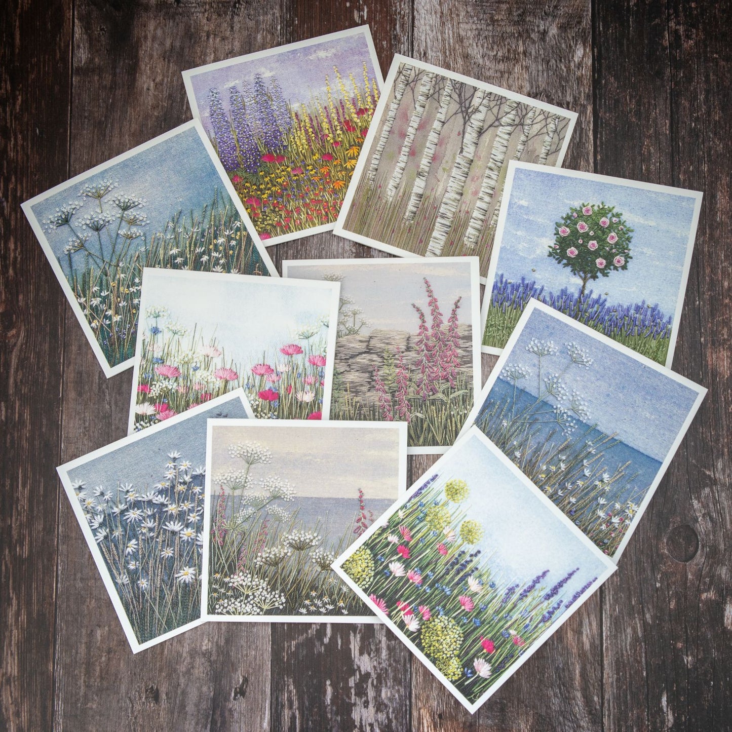 selection of 10 square greeting cards by Jo Butcher displayed on a wood effect backing board