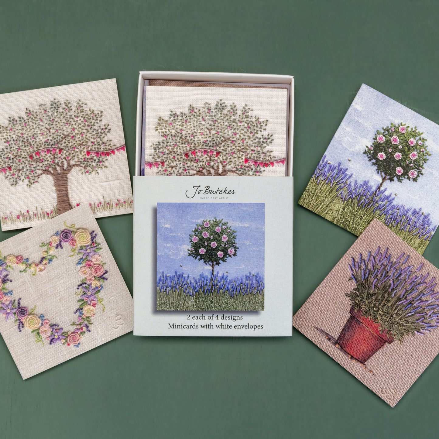 Open box of small square cards with the 4 different designs around the side.