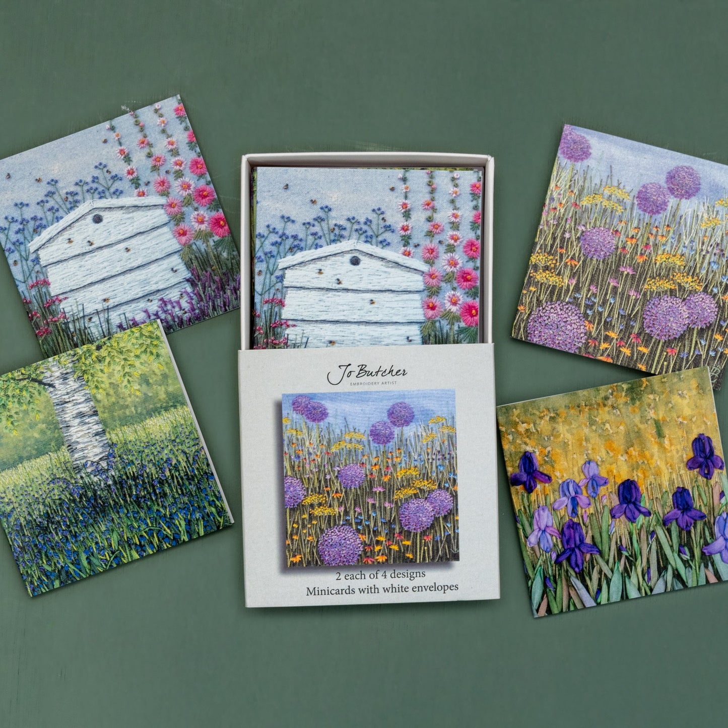 Open box of small square cards with the 4 different designs around the side.