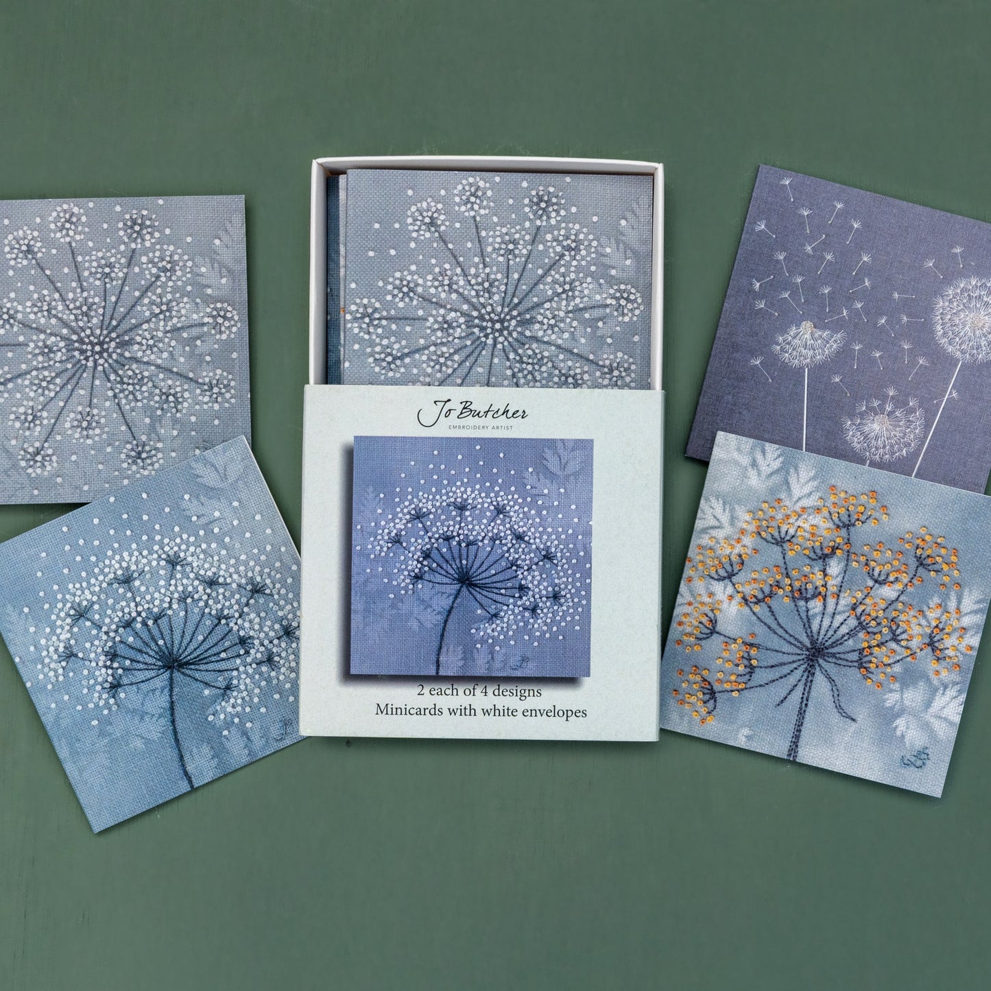 Open box of small square cards with the 4 different designs around the side.