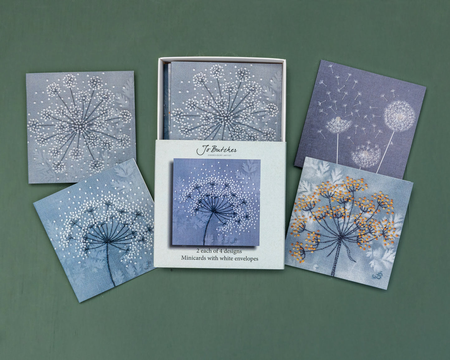 Open box of small square cards with the 4 different designs around the side.