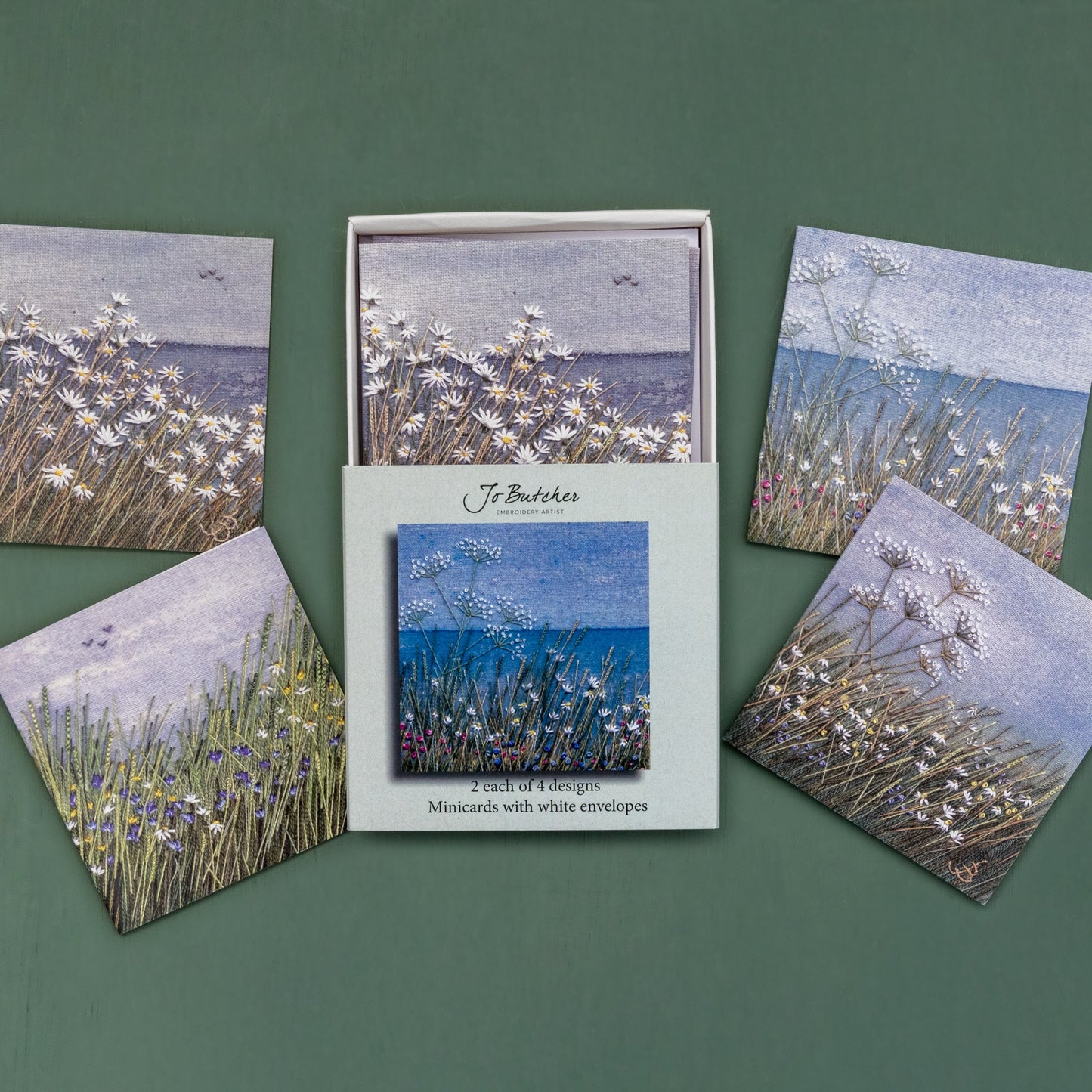 Open box of small square cards with the 4 different designs around the side.