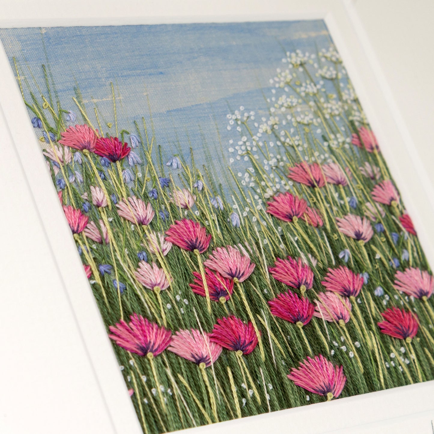 lots of pink poppies of various shades with small blue flowers and cow parsley create this soft embroidered artwork.