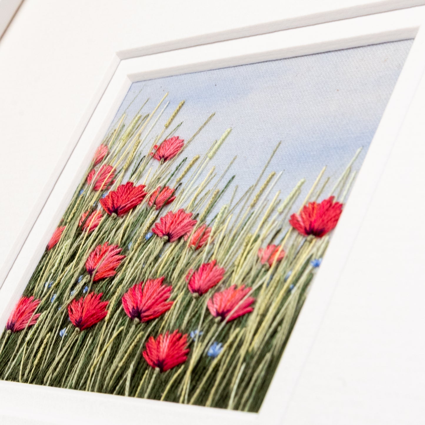 the stitch detail of the flowering grasses and poppies are the focus here.