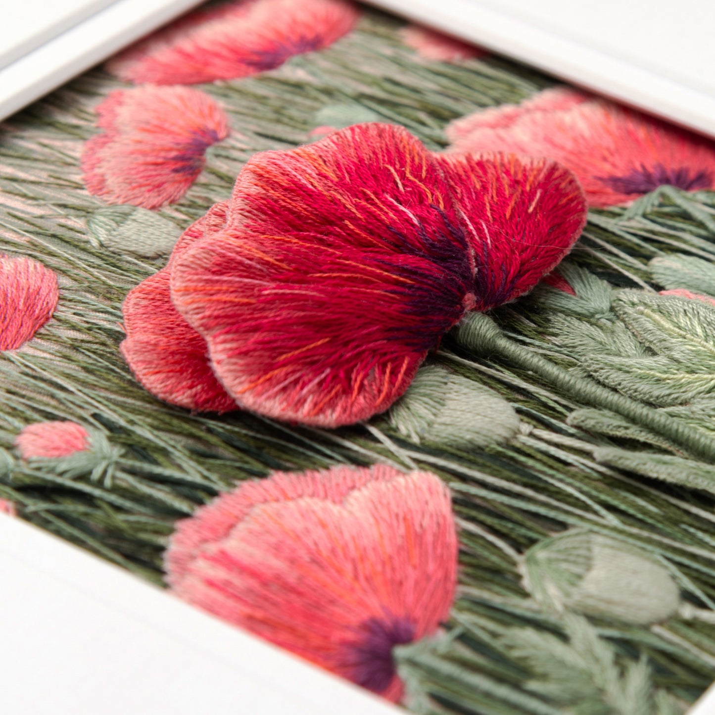 A fully embroidered background of poppies and poppy seed heads sets off a large red stumpwork poppy and stalk