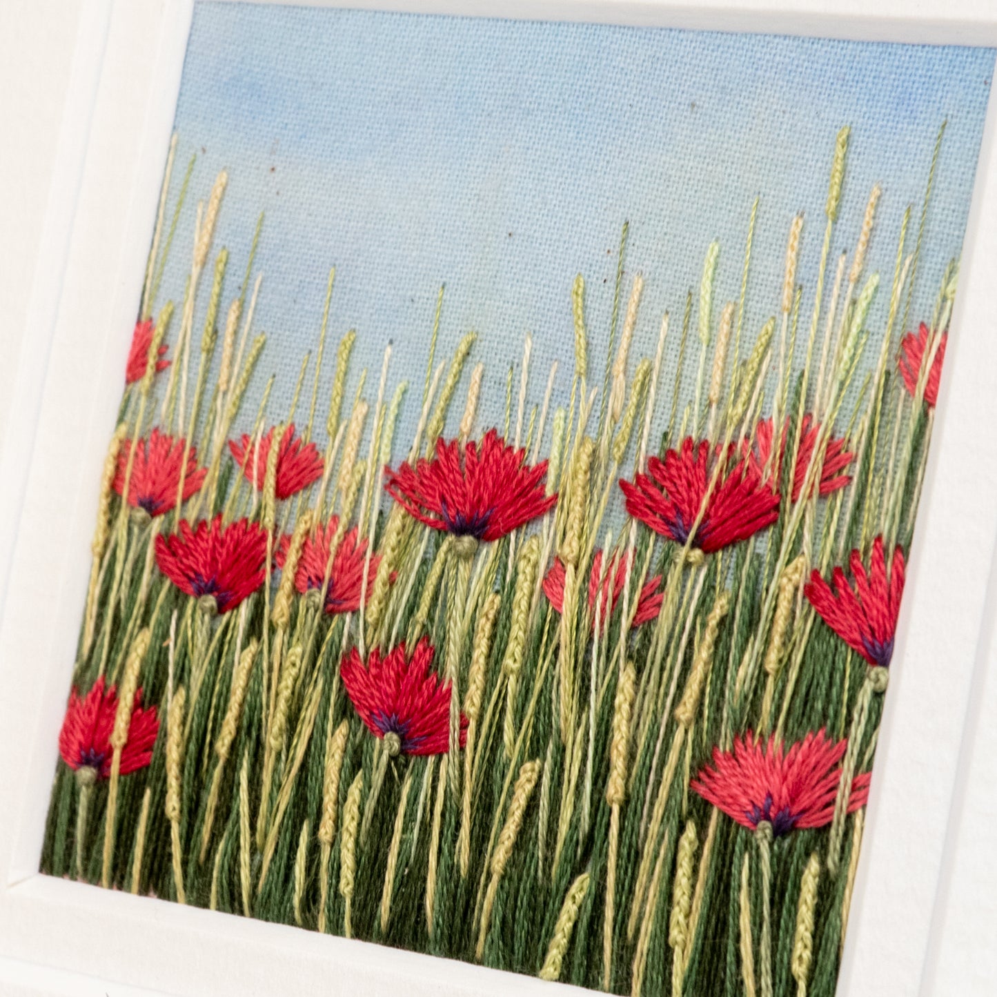 Angled view of the stitch detailing in this red poppy meadow.