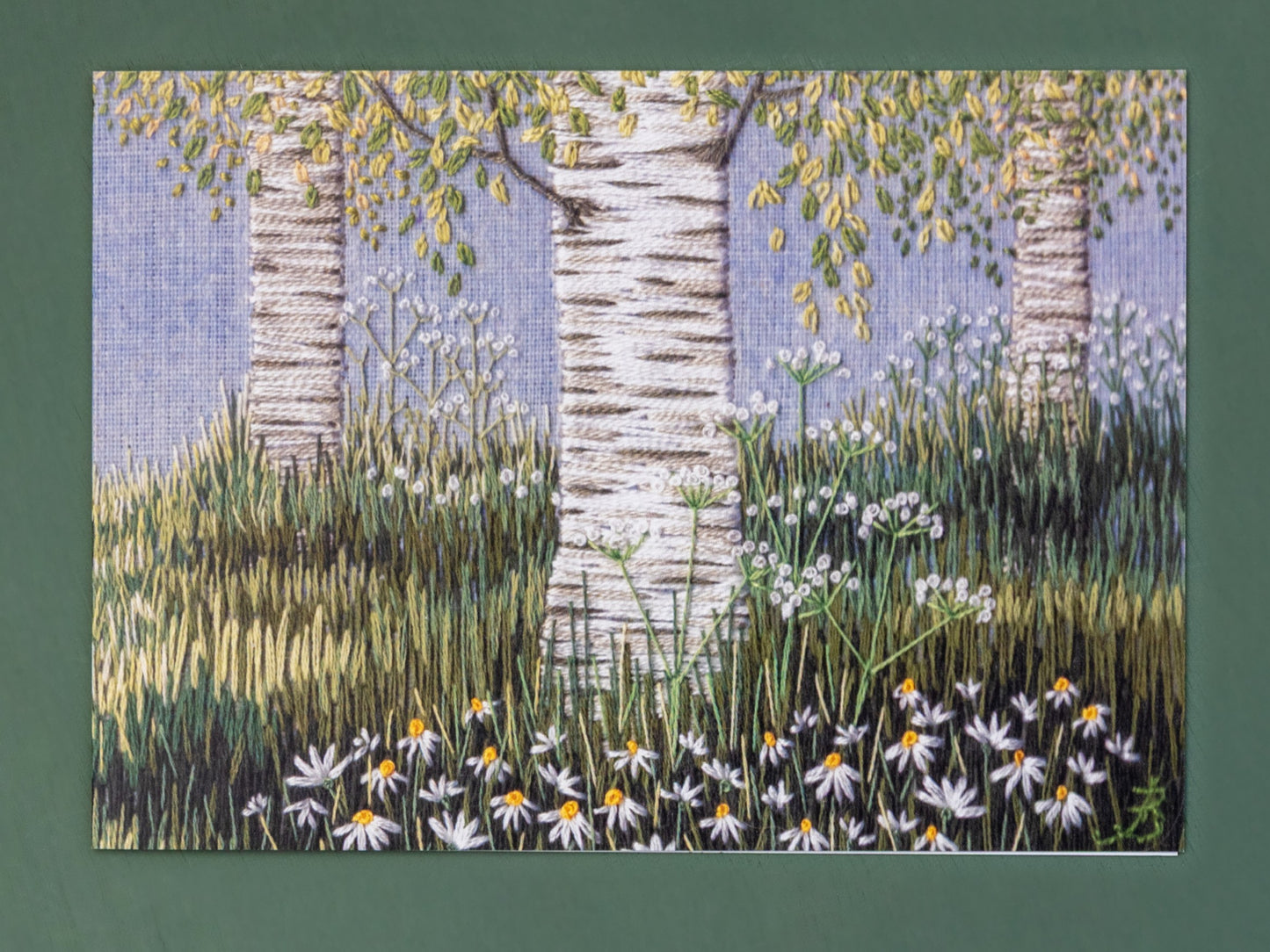 Hand embroidery scene of three silver birches amongst the grasses.