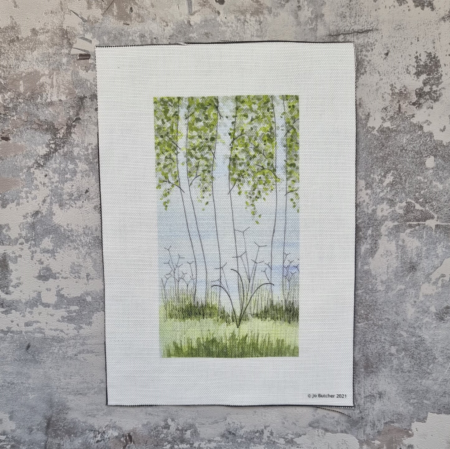 A portrait rectangular piece of cotton linen with a printed outline of three silver birch trees with grasses and cow parsley underneath for sewing over.