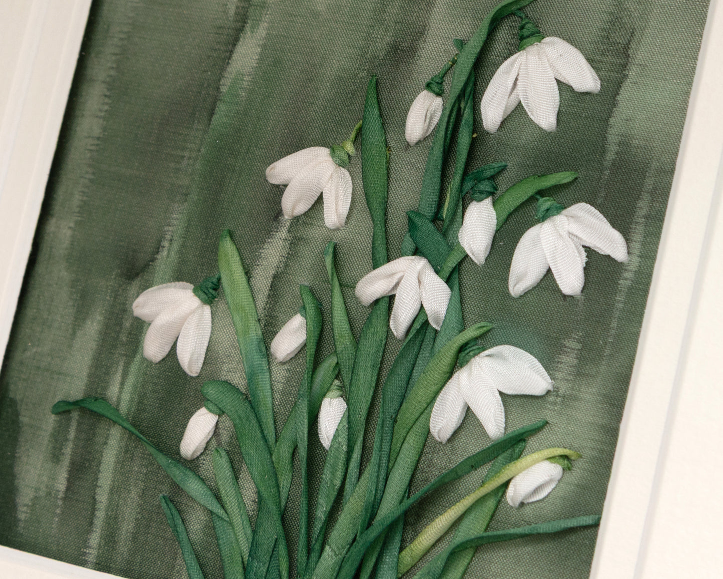Detailed view of the ribbon embroidered snowdrop clump.