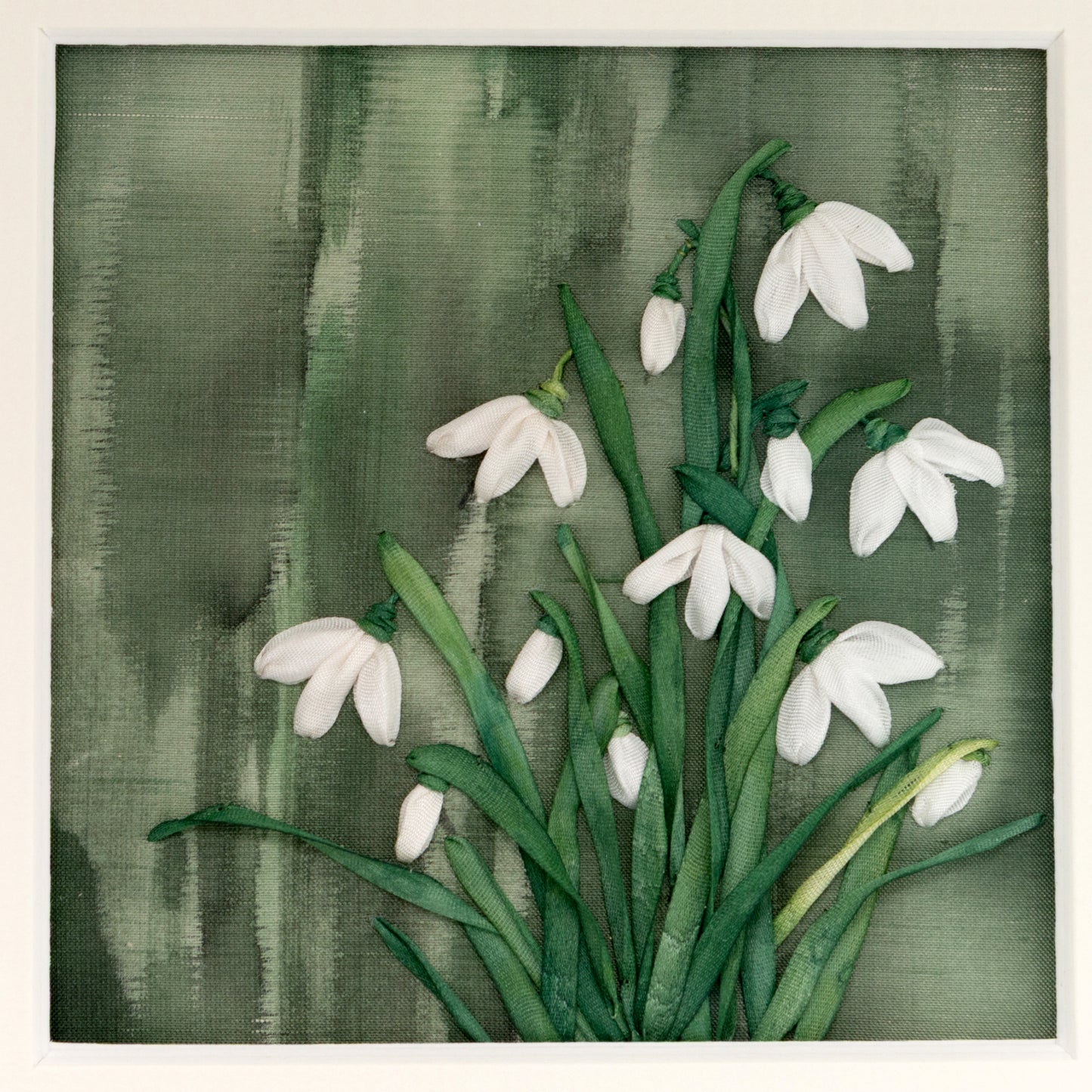 Clump of silk ribbon snow drops on a painted silk background.