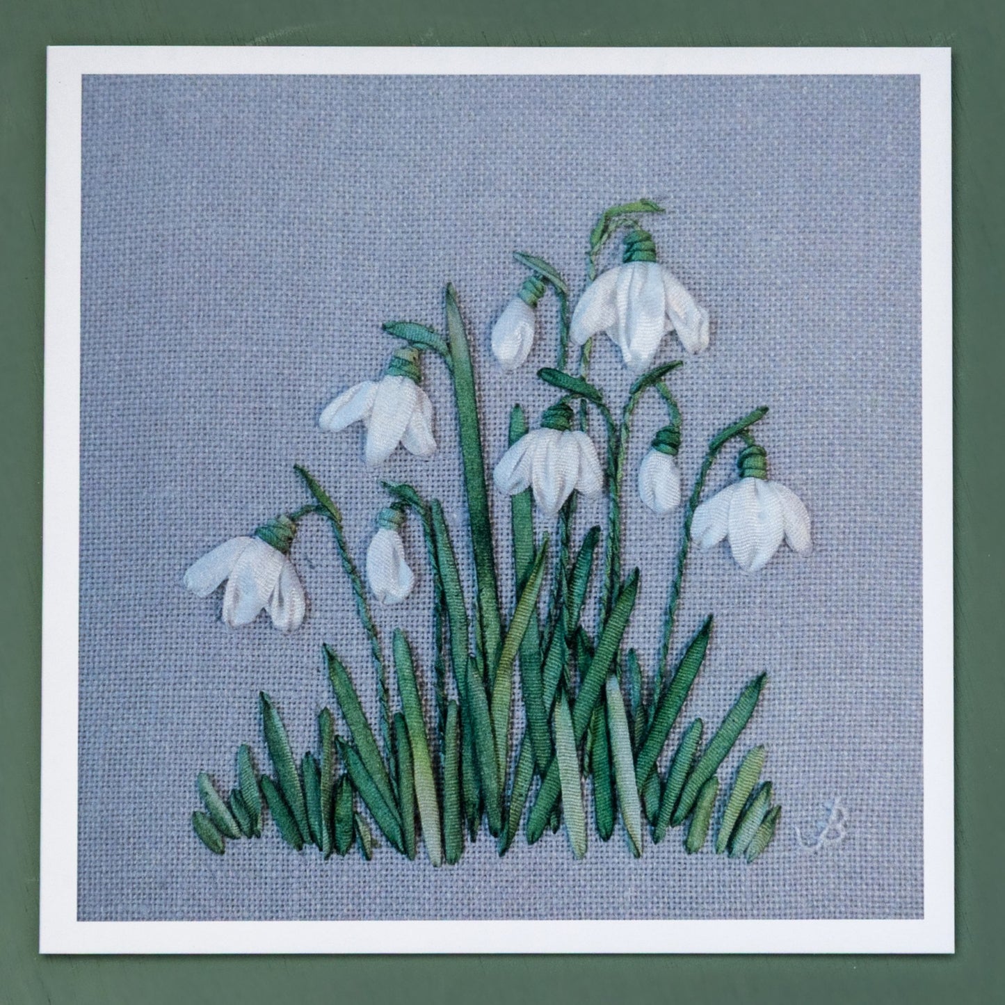 printed card of a clump of snowdrops embroidered using hand dyed silk green and white ribbons.