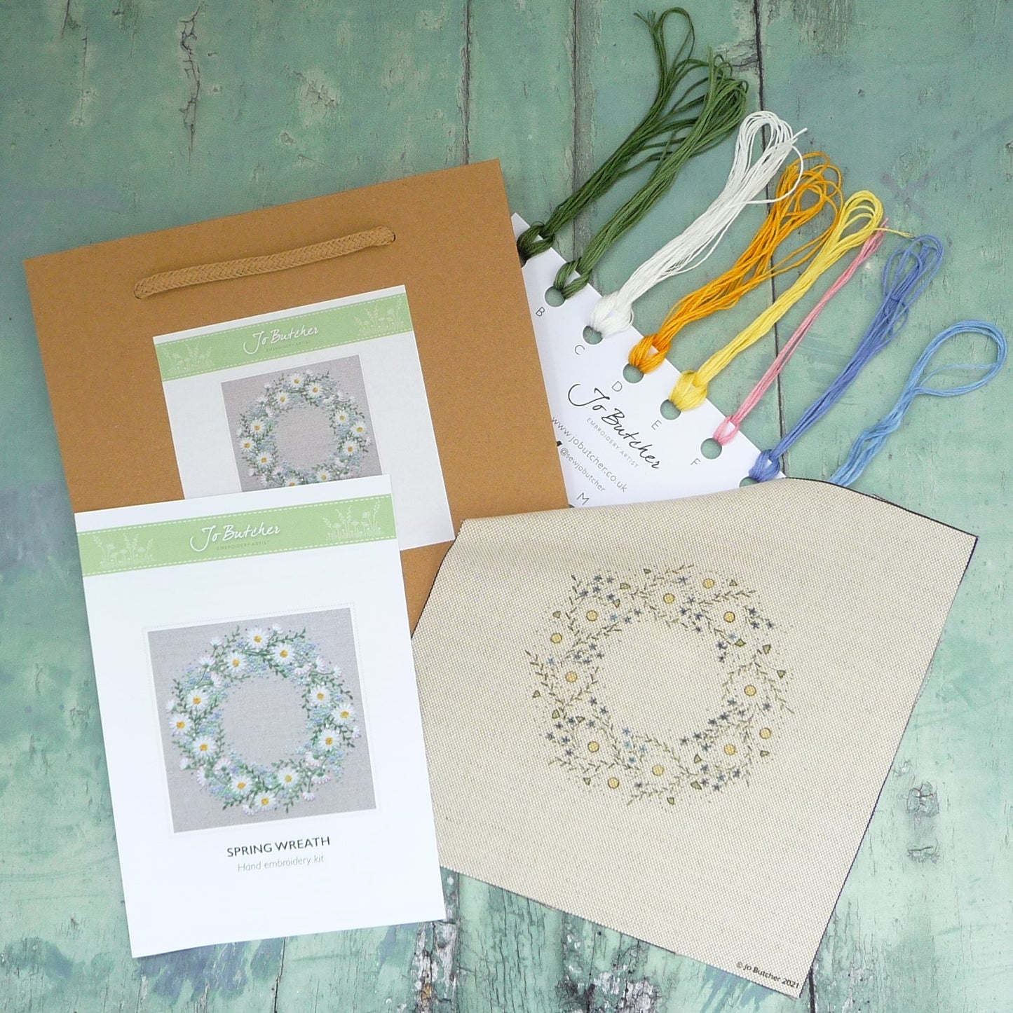 thread card with threads, printed background, and step by step instructions come in a brown paper bag.