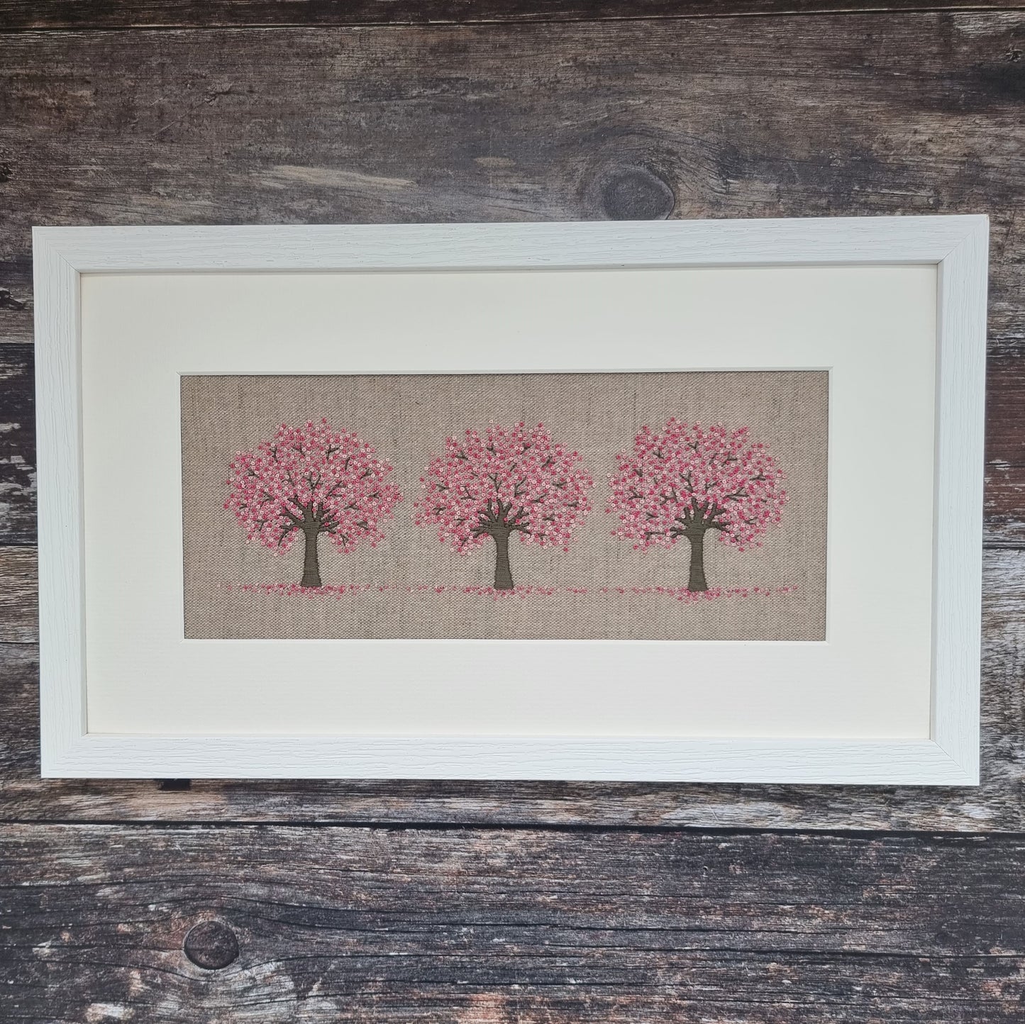 The completed kit of three cherry trees with pink blossom framed in a white frame and mount