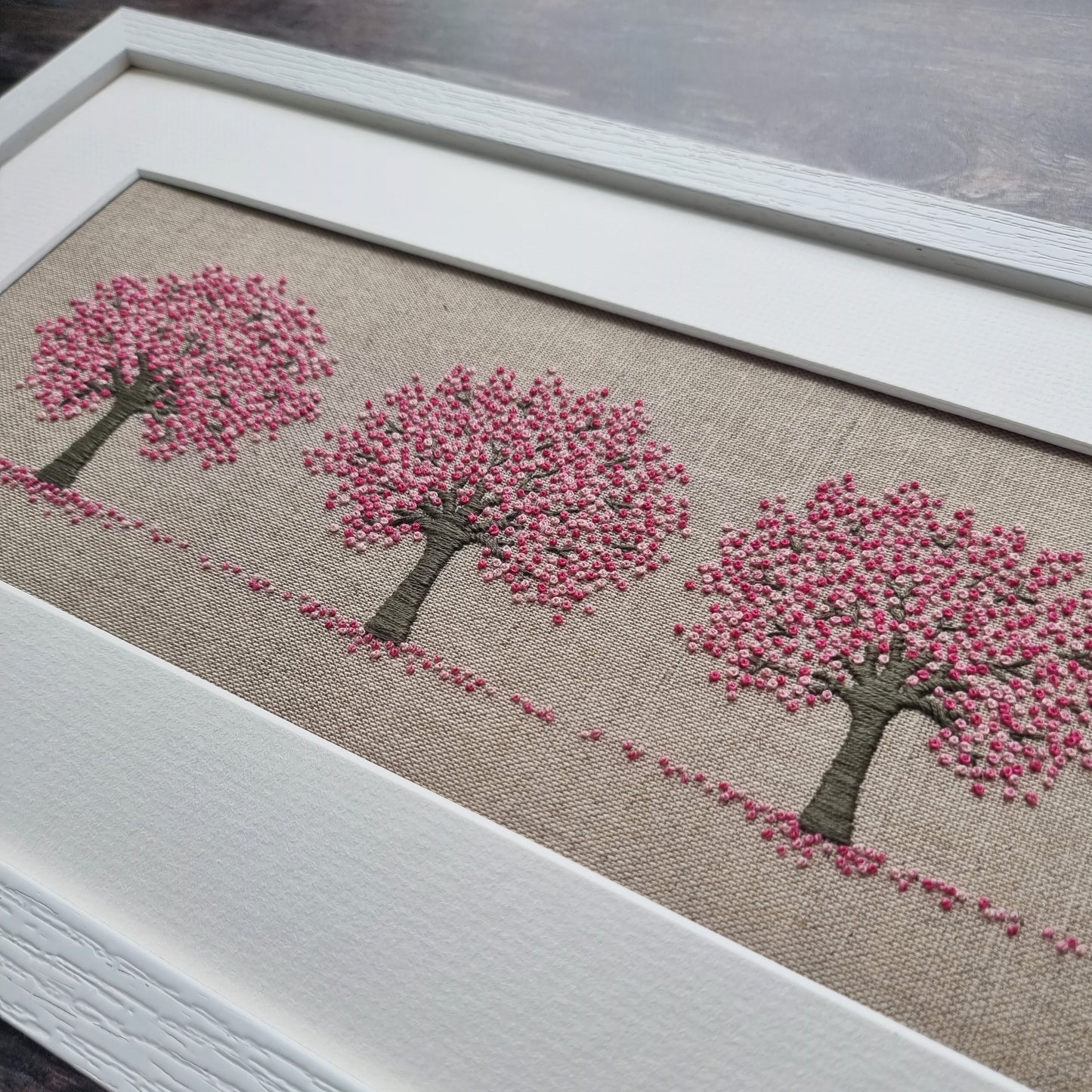 Finished and framed kit of three pink cherry trees in close up showing the details of the frame and stitching