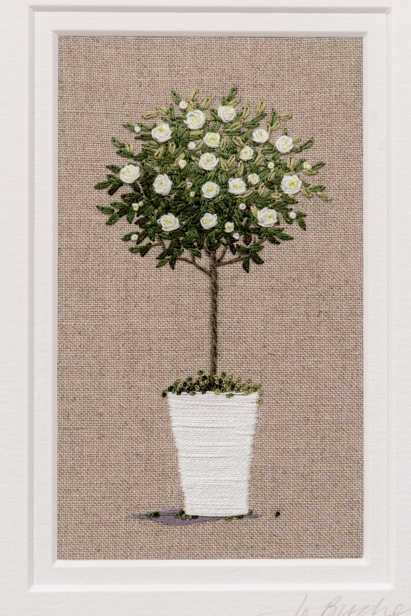 Hand embroidered artwork of a white standard rose in a white pot on beige linen background