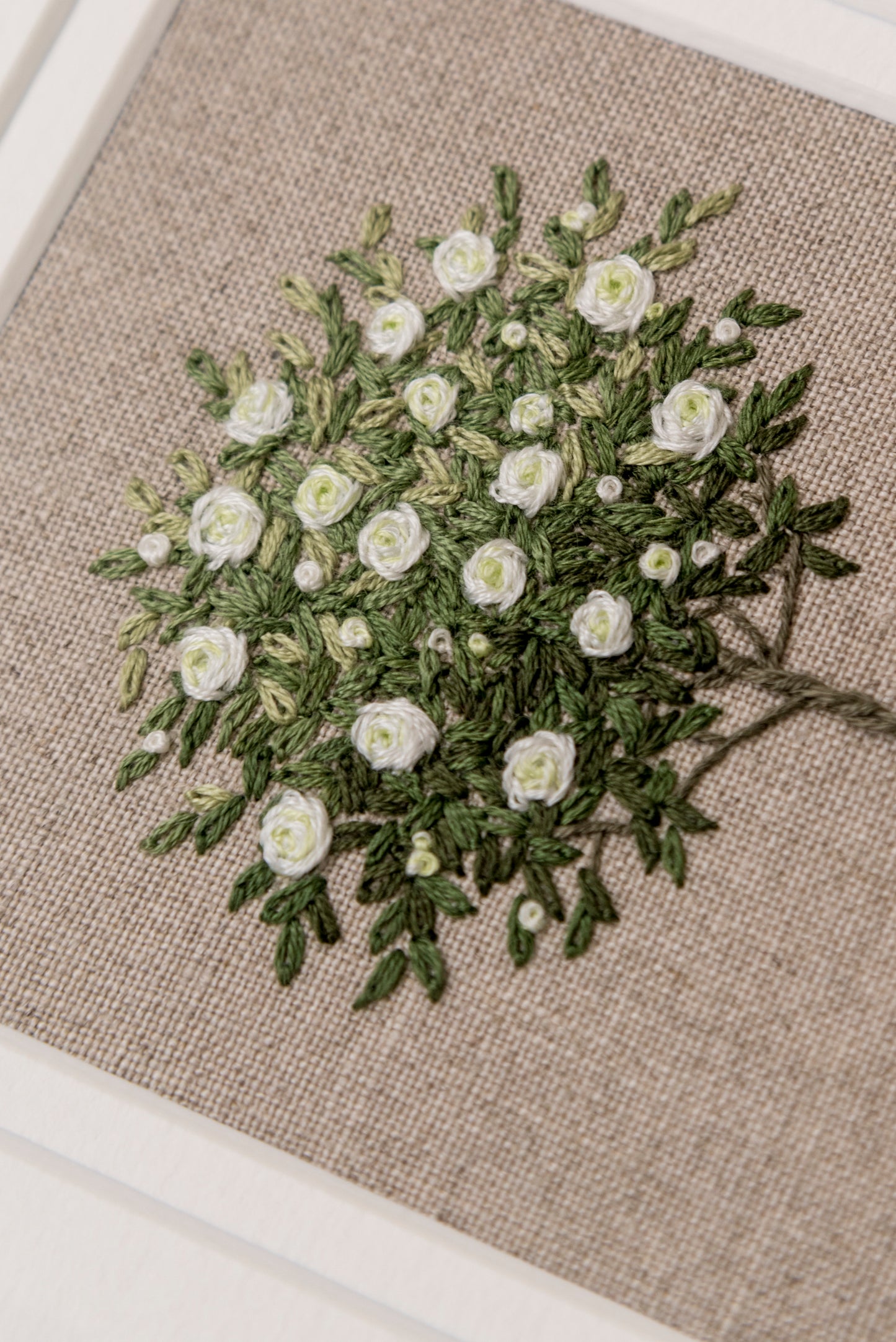angled close up of white rose tree hand embroidered artwork by jo butcher