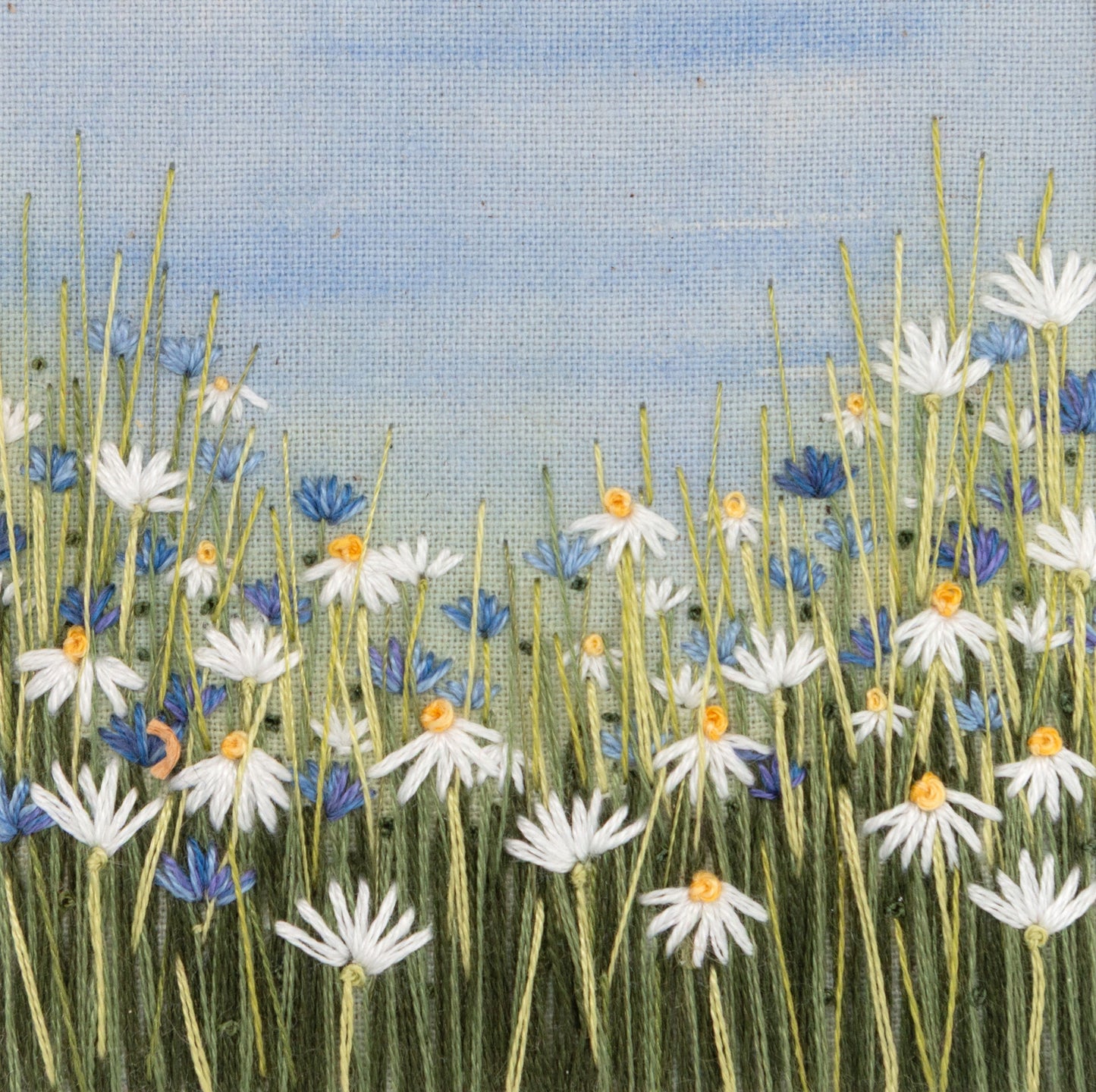 Close up detail of the embroidered daises and cornflowers.