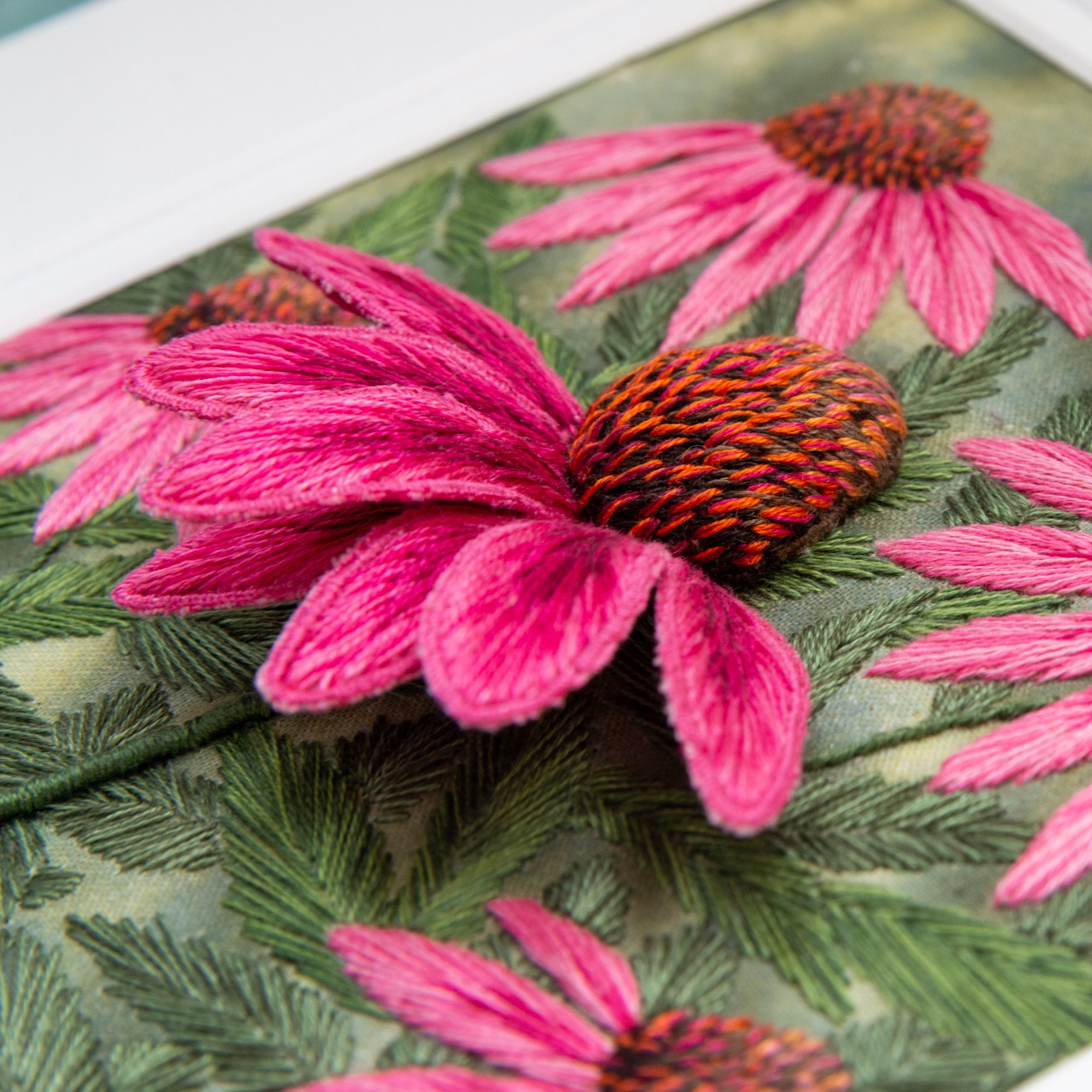 stump work of pink echinacea flower on embroidered background