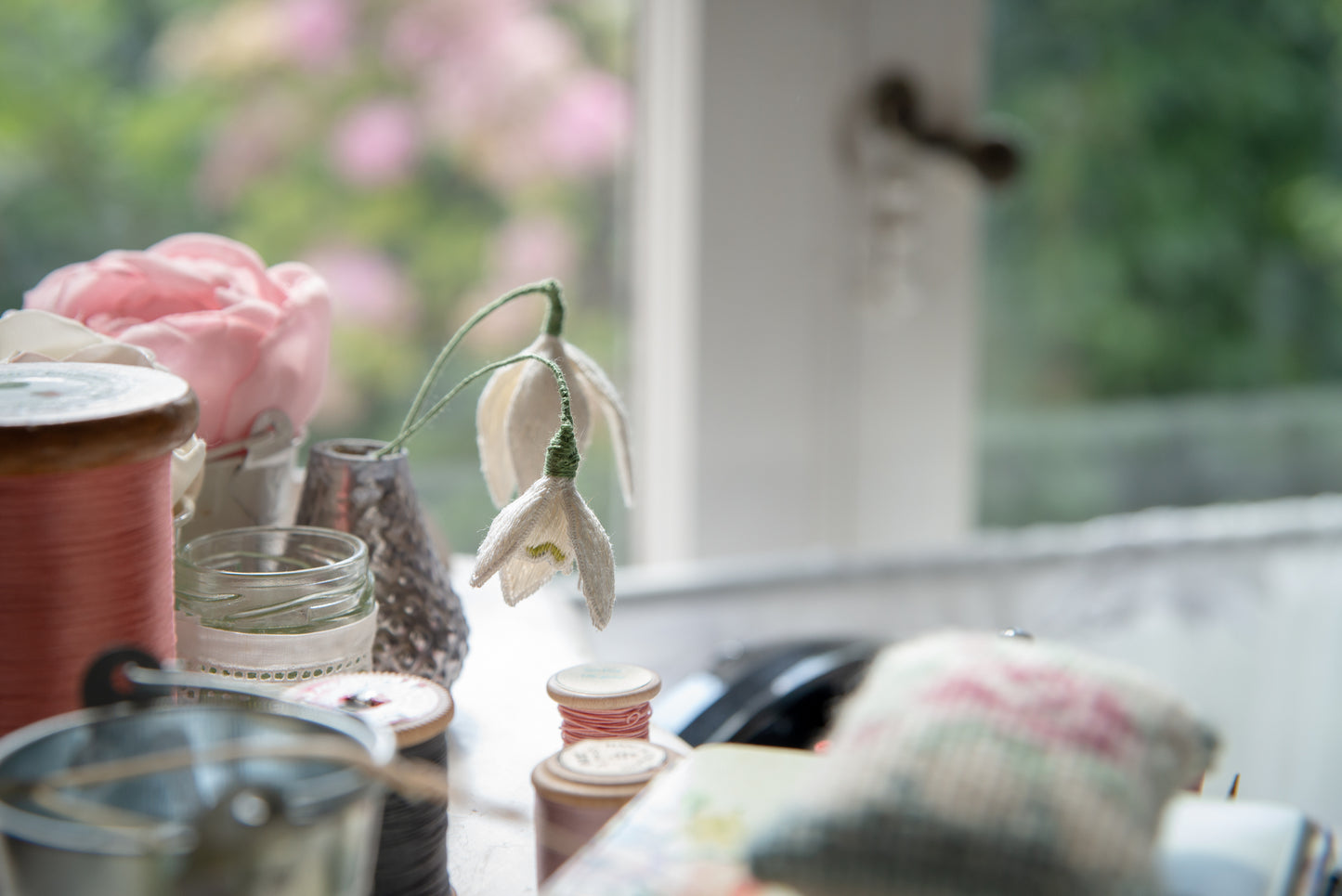 stumpwork snowdrops in glass vase staged with cotton reels