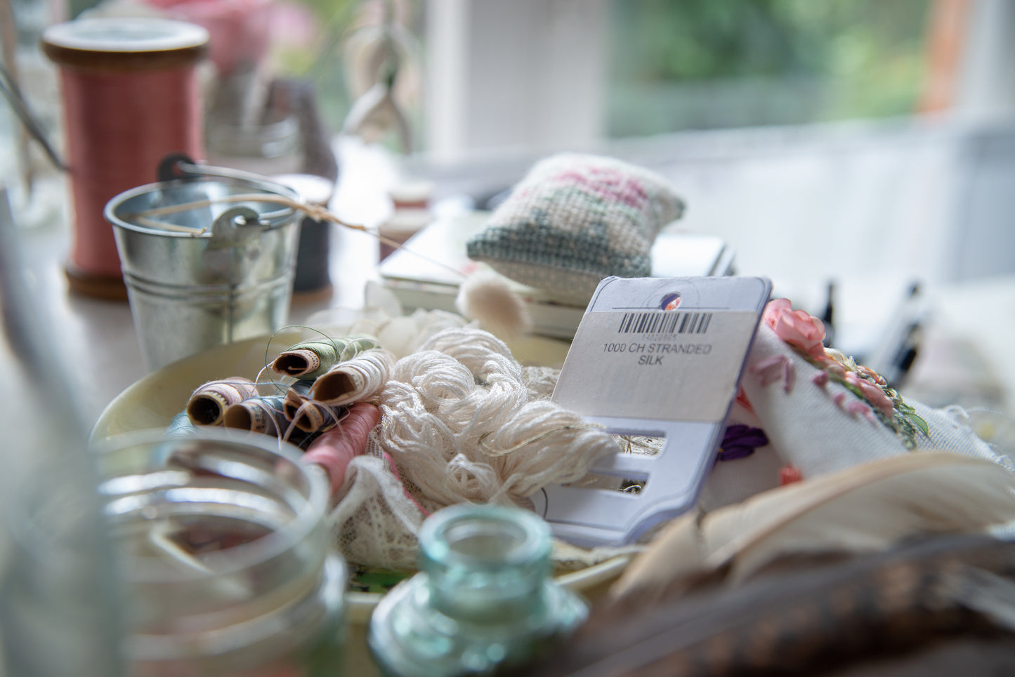 collection of threads, glass pots and other items staged for photo