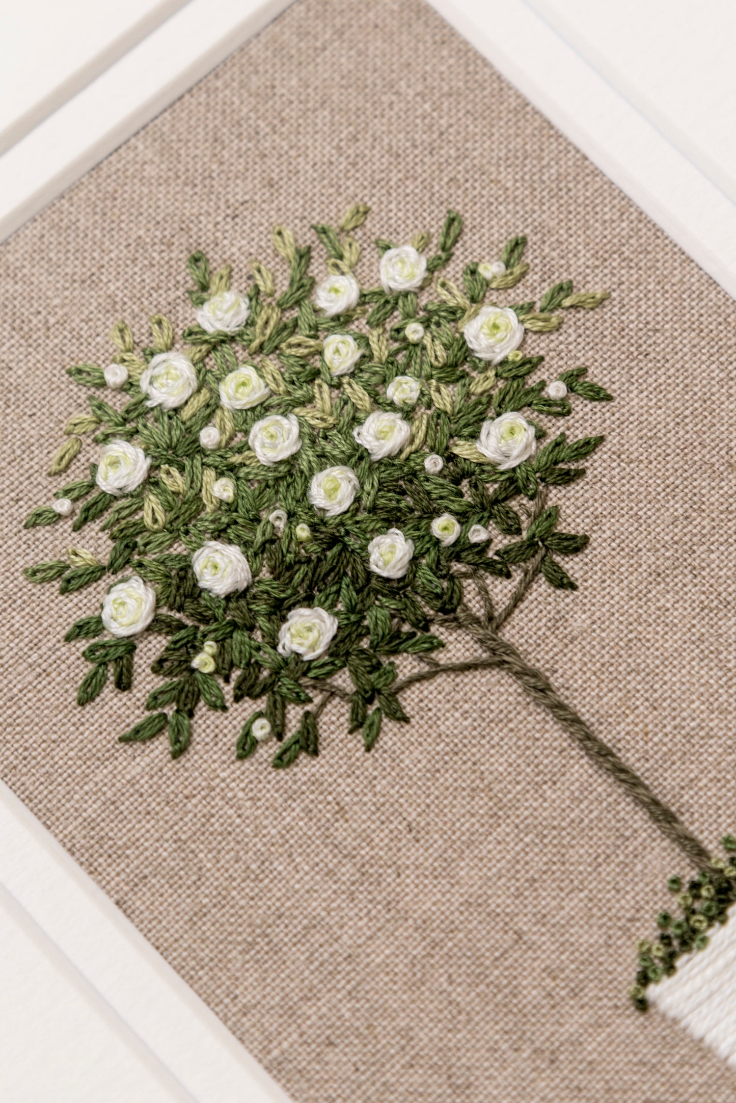 angled close up of white rose tree hand embroidered artwork by jo butcher
