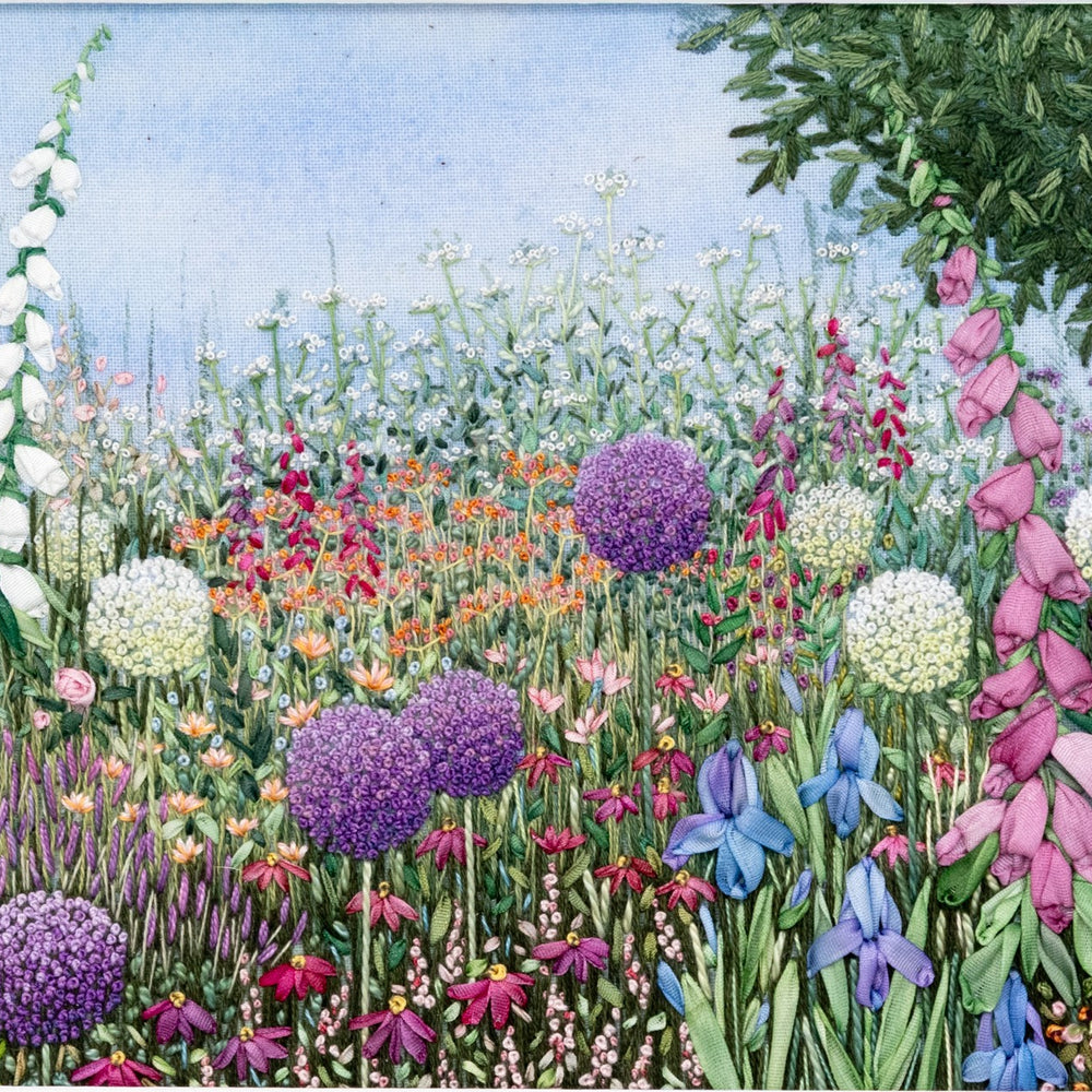 A colourful flower border of foxgloves and irises stitched using hand dyed silk ribbons. white and purple alliums,  mixed in with other colourful flowers and a bay tree rising above.