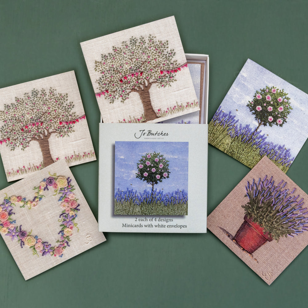 Open box of small square cards with the 4 different designs around the side.