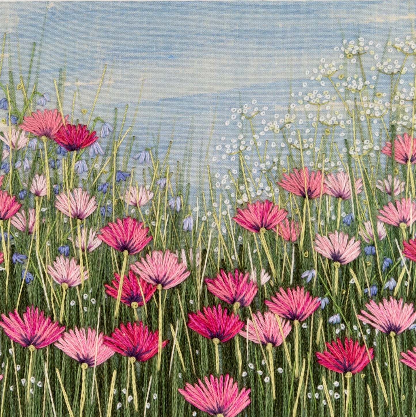 A variety of poppies stitched in shades of pink along with some fluffy cow parsley. 