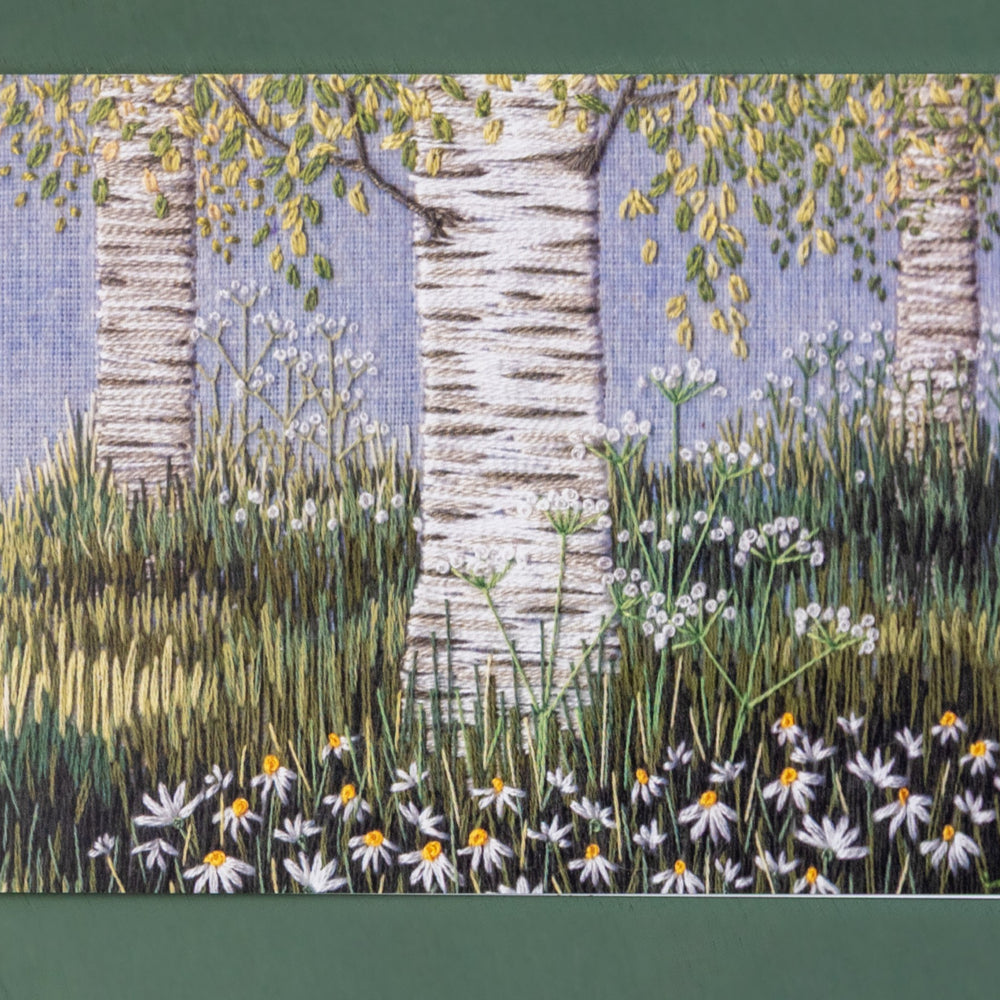 Hand embroidery scene of three silver birches amongst the grasses.