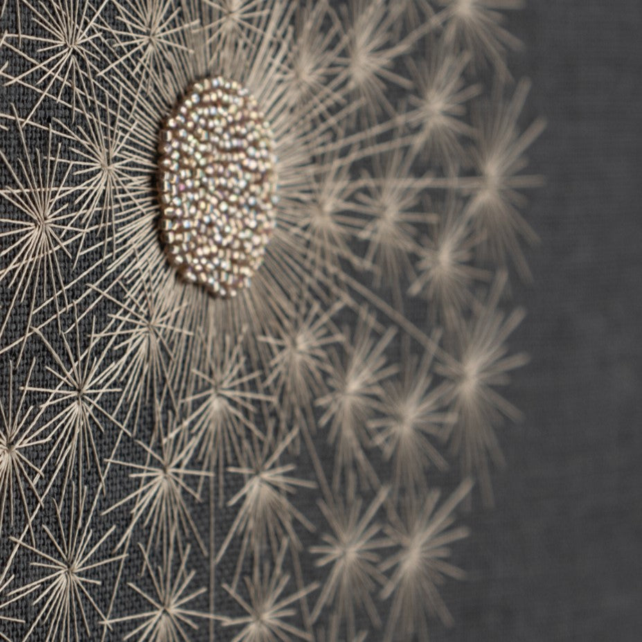 close up of a dandelion clock embroidered with glass beads and silk thread